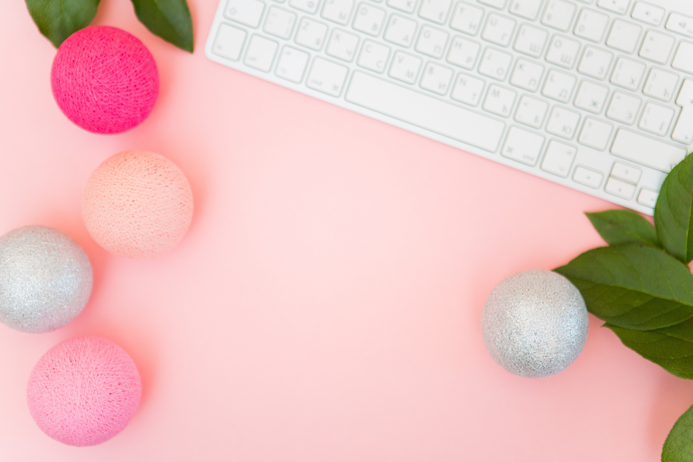 Top View of Keyboard and Pearls on Pink Background